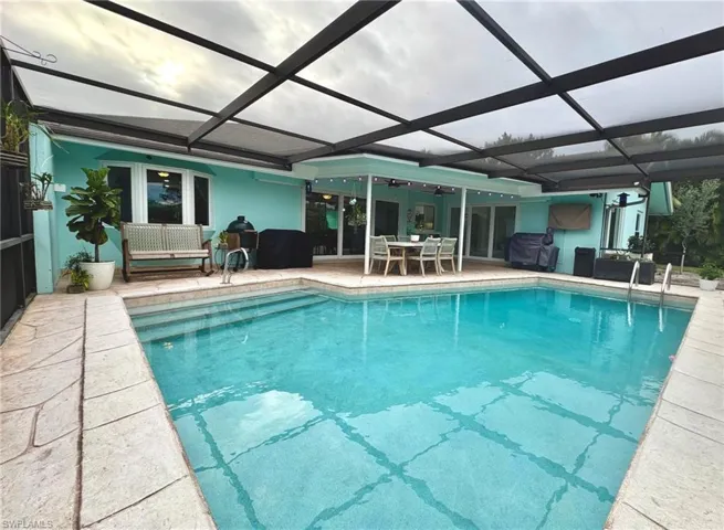 View of pool with ceiling fan, a lanai, and a patio