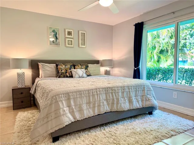 Tiled bedroom featuring ceiling fan