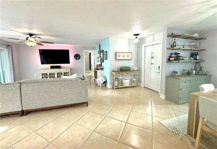 Tiled living room featuring ceiling fan and a textured ceiling