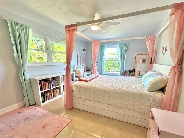 Bedroom featuring ceiling fan, light tile patterned floors, and a textured ceiling