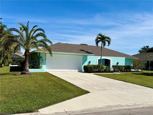 Ranch-style home with a front yard and a garage