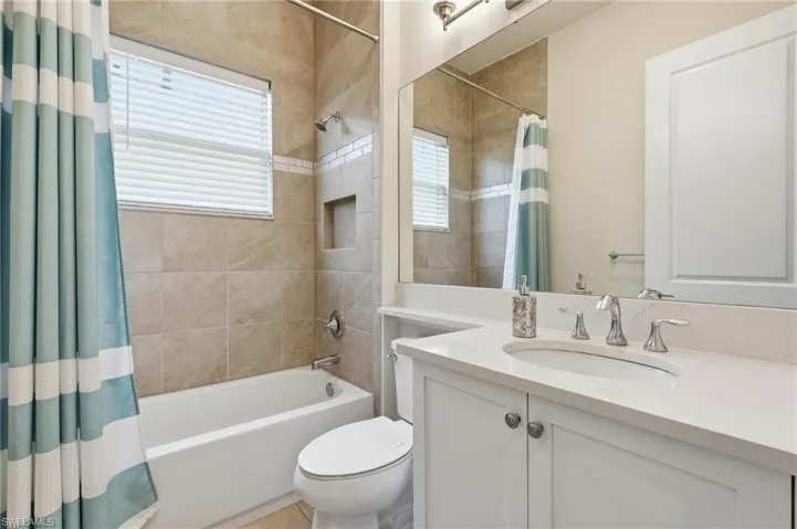 Bathroom featuring a white vanity with a sink, polished chrome faucet and expansive mirror