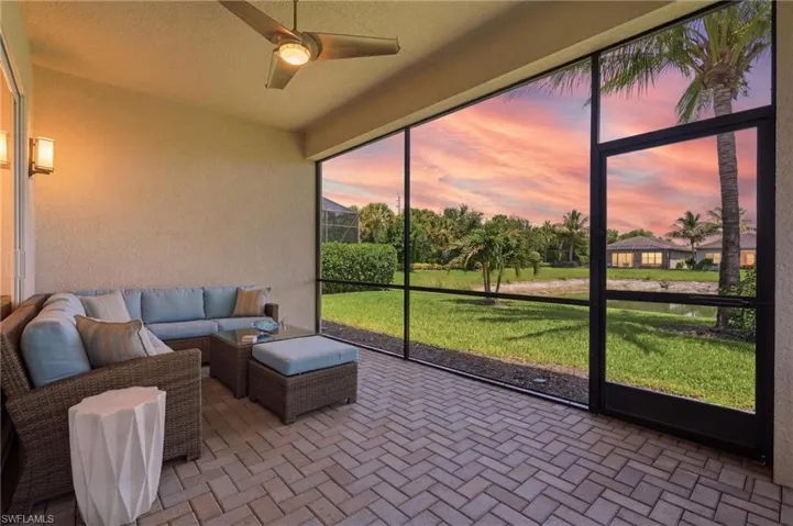Screened lanai has herringbone paver pattern flooring and a ceiling fan lighting.