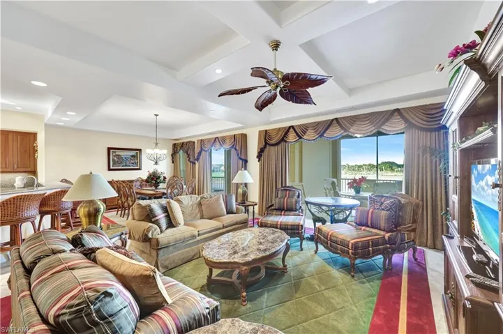 Living area with ceiling fan, recessed lighting, coffered ceiling, a chandelier, and a tray ceiling