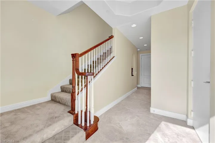 Stairway with baseboards and recessed lighting