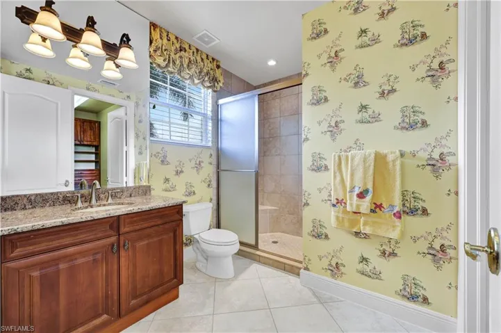 Full bathroom with wallpapered walls, a shower stall, light tile patterned flooring, vanity, and recessed lighting