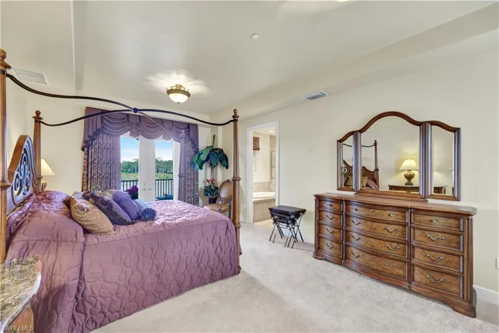 Bedroom featuring french doors, carpet flooring, access to outside, and ensuite bathroom