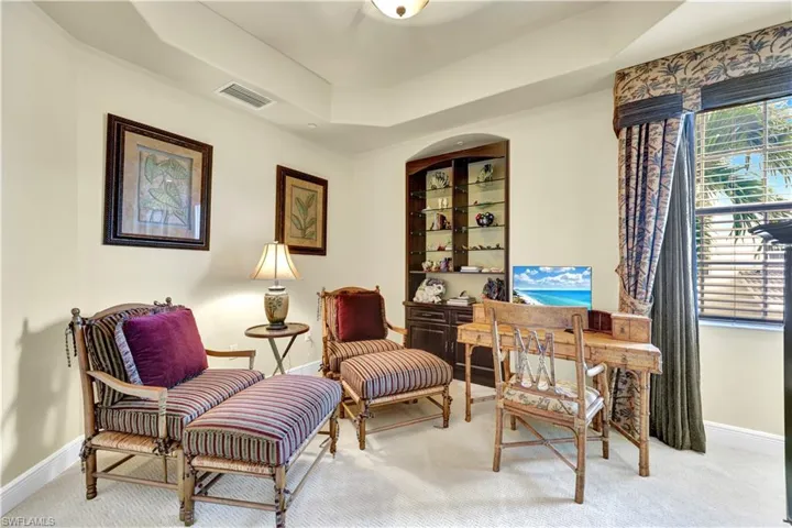 Sitting room with a raised ceiling and carpet floors