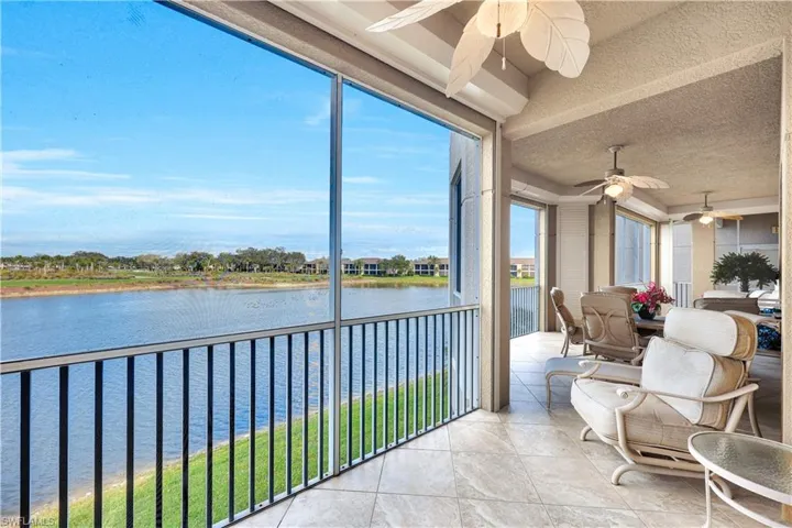 Sunroom / solarium with a textured ceiling, a water view, and tile patterned flooring