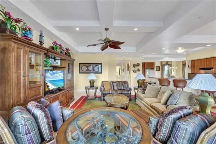 Living area with coffered ceiling, recessed lighting, arched walkways, and beamed ceiling