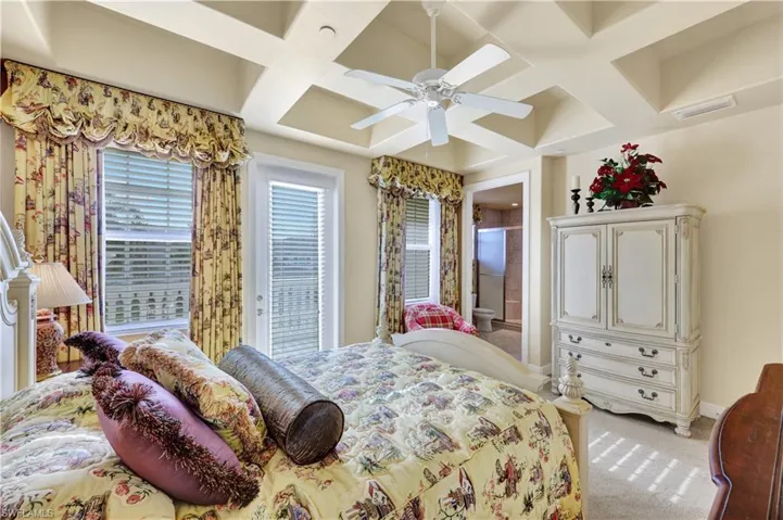 Bedroom featuring coffered ceiling, carpet flooring, a ceiling fan, and beamed ceiling