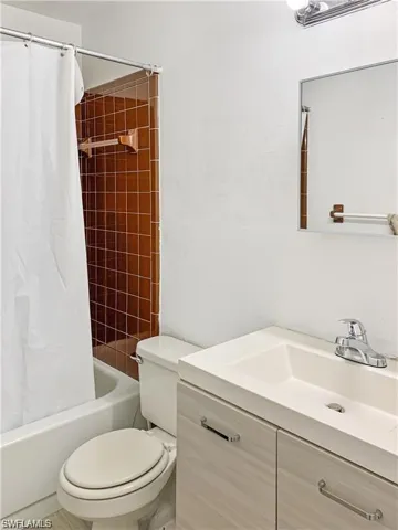 Full bathroom featuring vanity, shower / tub combo, and toilet