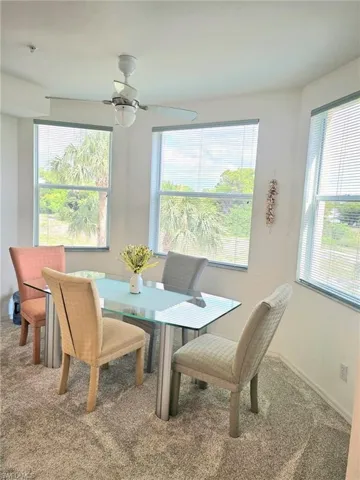 Dining area with carpet flooring, plenty of natural light, and ceiling fan