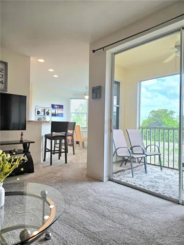 Living area featuring ceiling fan, light colored carpet, and recessed lighting