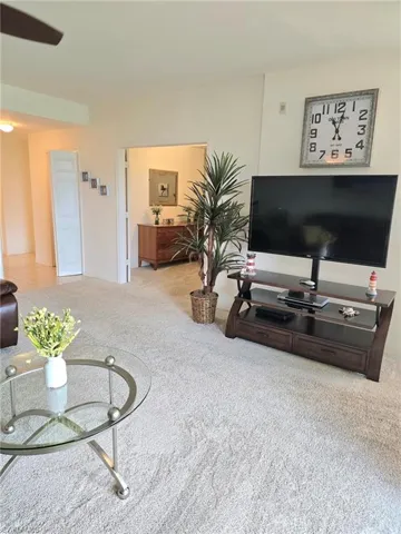 Living room featuring light colored carpet and ceiling fan