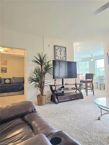 Carpeted living area featuring ceiling fan and recessed lighting