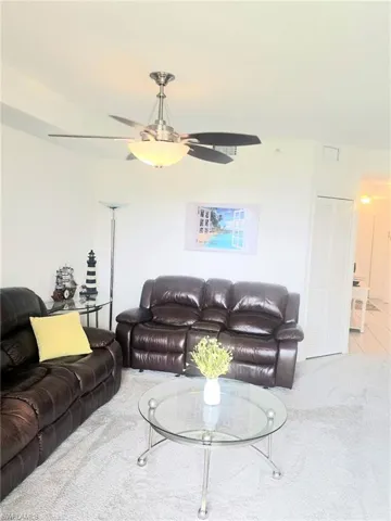 Living area with light carpet and a ceiling fan