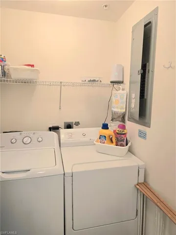 Laundry area featuring electric panel and washer and dryer