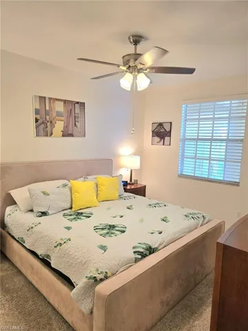 Carpeted bedroom featuring ceiling fan