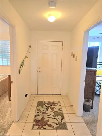 Entryway featuring carpet floors and tile patterned floors