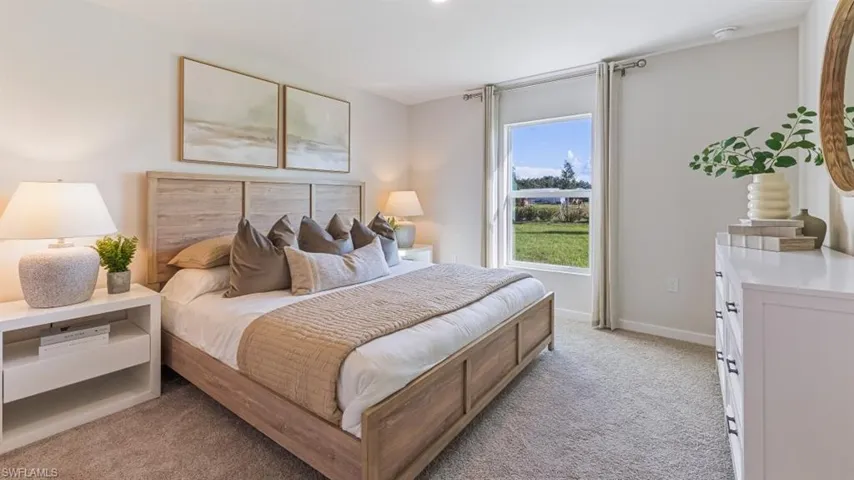 Model home. Bedroom featuring light carpet