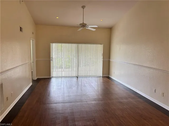 Unfurnished room featuring a textured wall, ceiling fan, dark wood finished floors, and recessed lighting