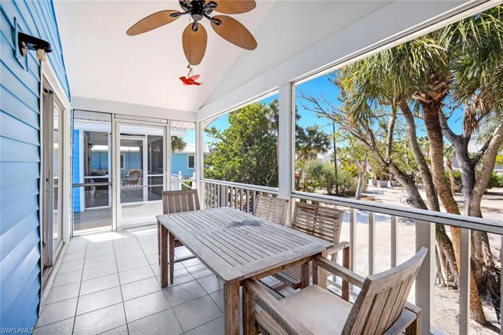 Sunroom with lofted ceiling, ceiling fan, and outdoor dining space