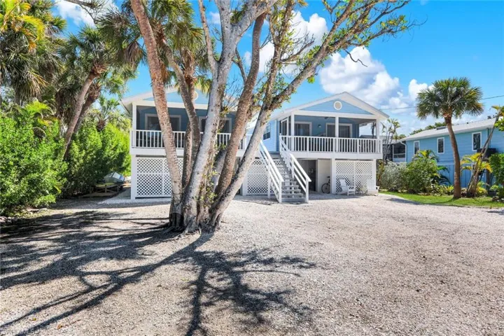 Rear view of house with driveway, a deck, and a sunroom