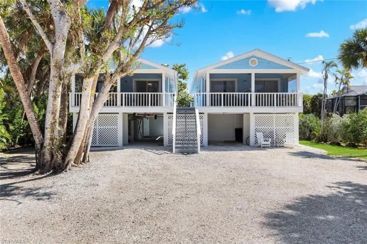 Coastal home featuring a carport, a deck, and driveway