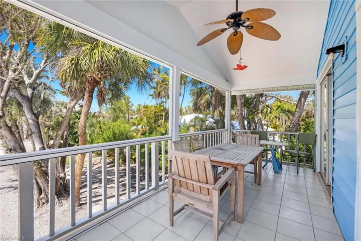 Sunroom with vaulted ceiling, ceiling fan, outdoor dining space, and a balcony