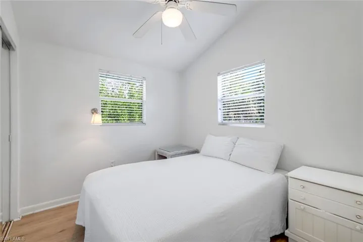 Bedroom featuring lofted ceiling, wood finished floors, a ceiling fan, and a closet