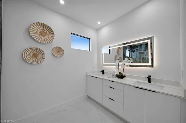 Full bathroom featuring marble finish flooring, double vanity, baseboards, and recessed lighting