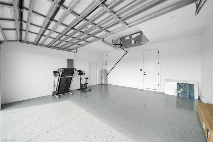 Garage with gas water heater and electric panel