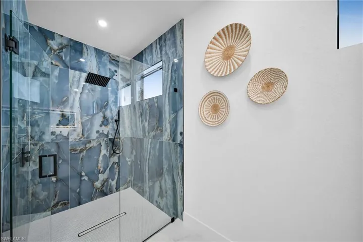 Bathroom featuring a marble finish shower, marble finish floors, and recessed lighting