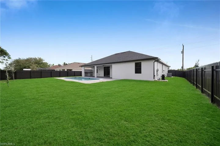 Back of property with stucco siding, cooling unit, a patio, and a shingled roof