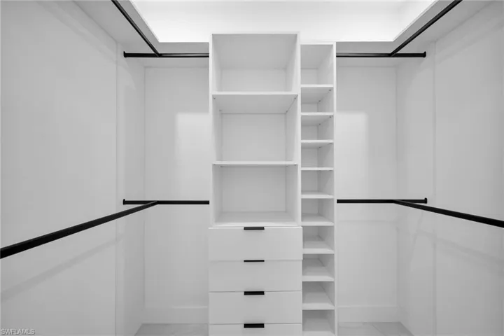 Walk in closet with light marble finish flooring