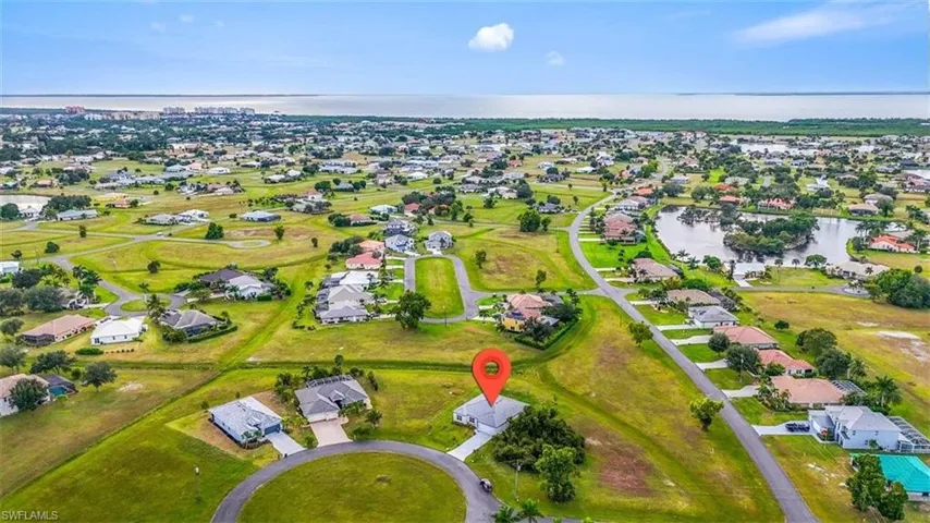 Aerial overview of property's location featuring a large body of water and nearby suburban area
