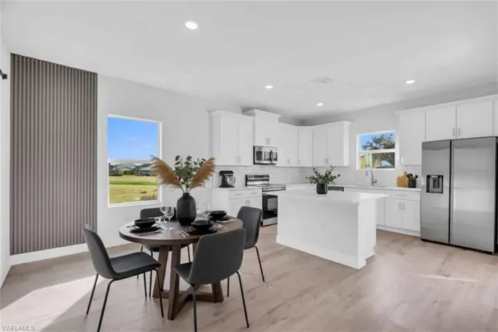 Virtually staged dining space with recessed lighting and light wood-style floors. Wall design not virtually staged.