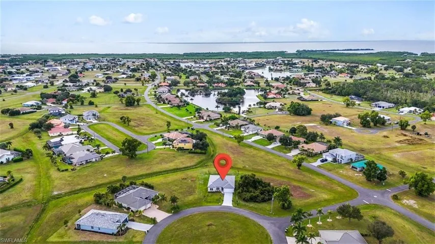 Aerial overview of property's location with a large body of water and nearby suburban area