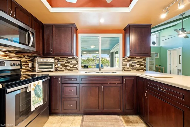Beautifully updated kitchen with wood cabinets, solid surface countertops & stainless steel appliances