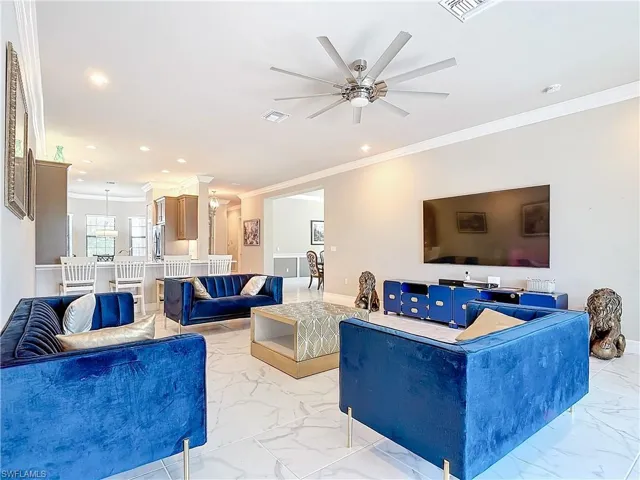 Living room with ornamental molding and ceiling fan