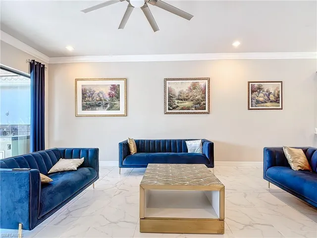Living room featuring ornamental molding and ceiling fan
