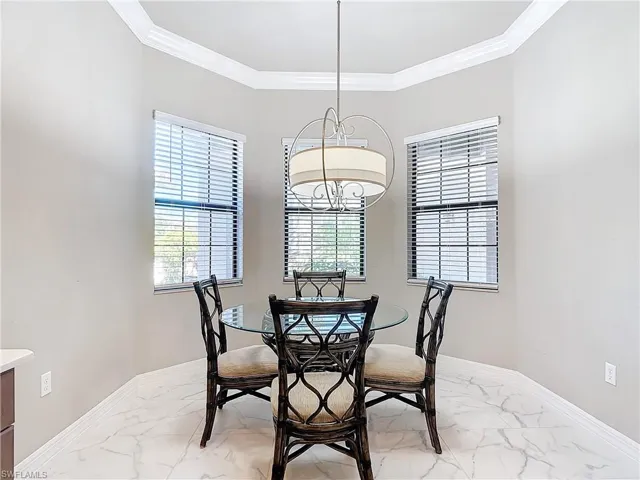 Dining room with a notable chandelier and ornamental molding