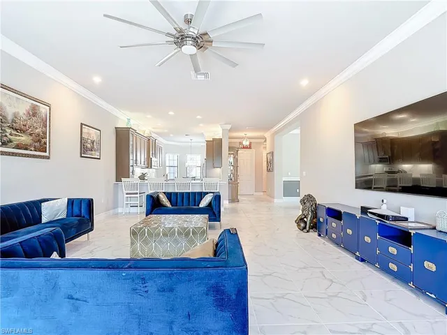 Living room with ornamental molding and ceiling fan