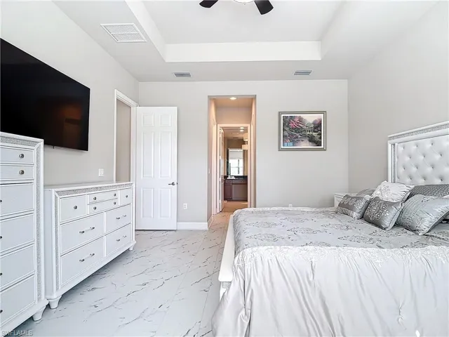 Bedroom with ceiling fan and a tray ceiling
