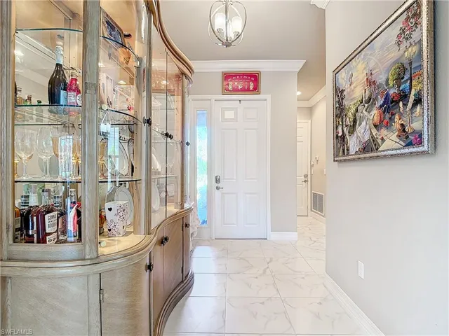 Entryway with crown molding and an inviting chandelier