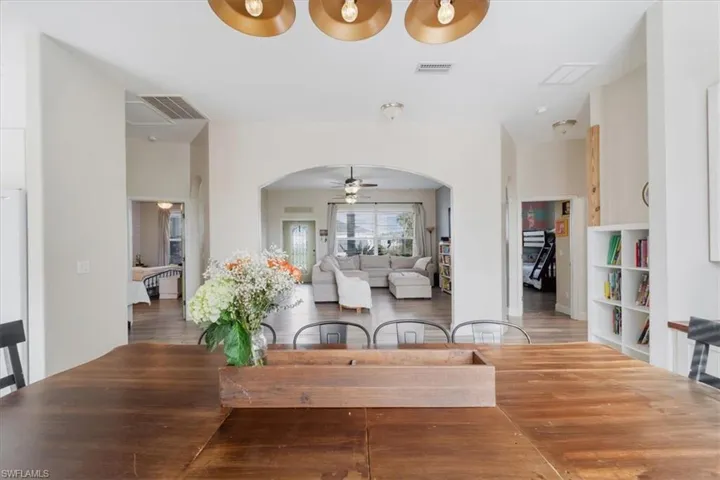 Dining room featuring arched walkways, visible vents, and a ceiling fan