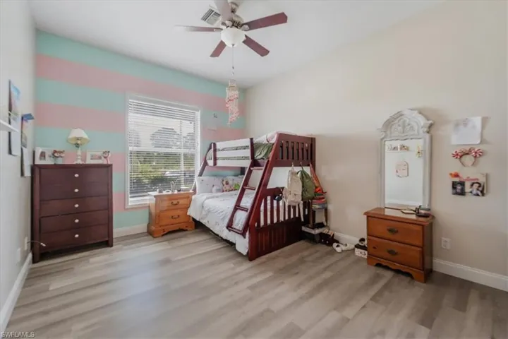 Bedroom with wood finished floors, baseboards, and a ceiling fan