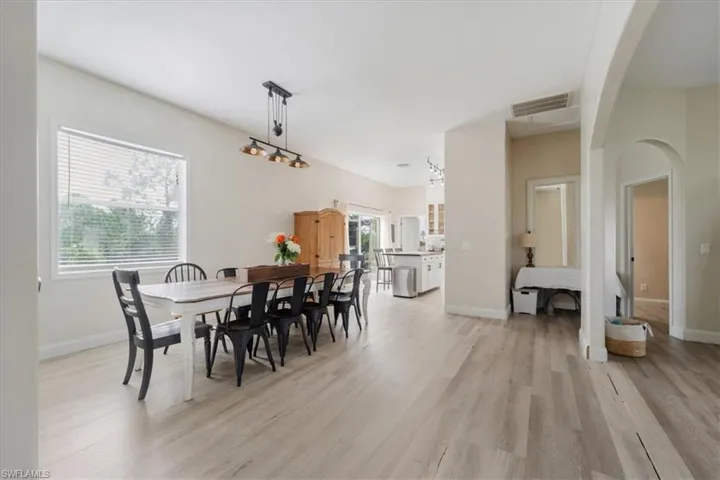 Dining room featuring visible vents, a wealth of natural light, light wood-type flooring, and arched walkways
