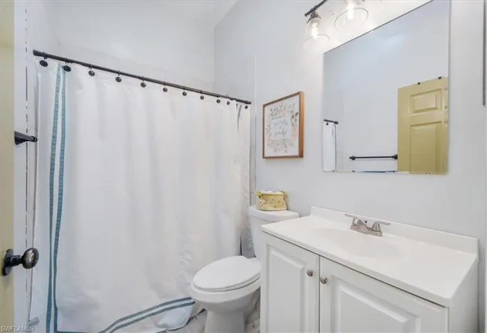Full bath featuring toilet, vanity, and a shower with curtain